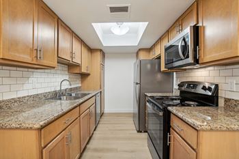 A kitchen with wooden cabinets and granite countertops.